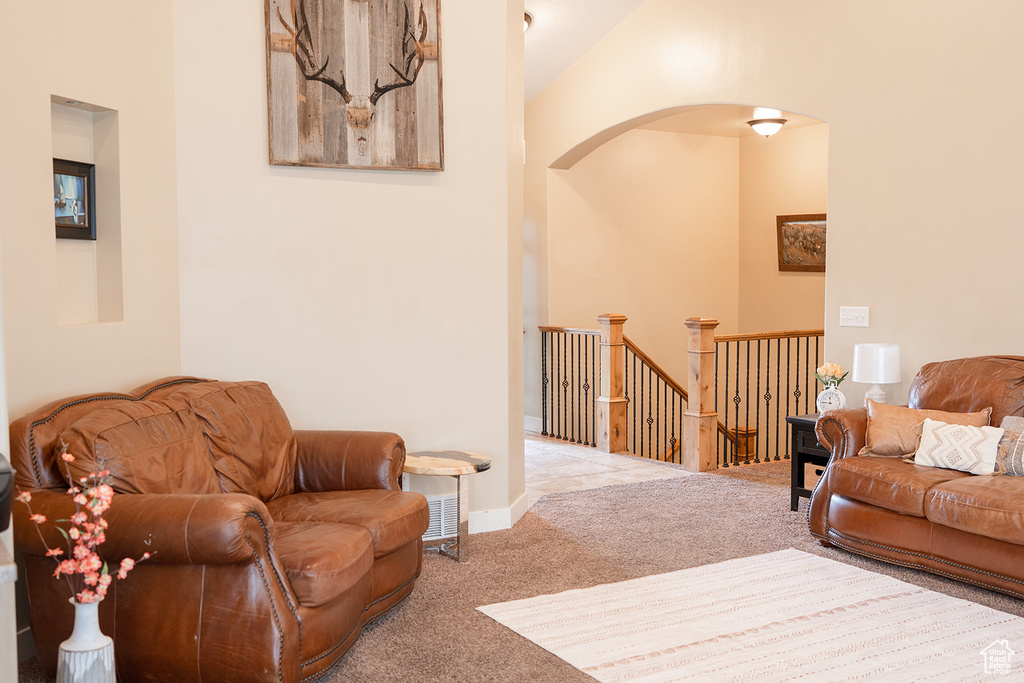 Carpeted living area featuring arched walkways