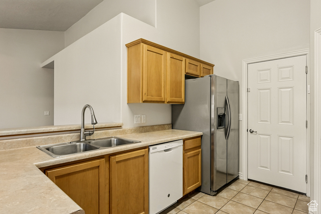 Kitchen featuring dishwasher, a sink, stainless steel fridge with ice dispenser, light countertops, and light tile patterned floors
