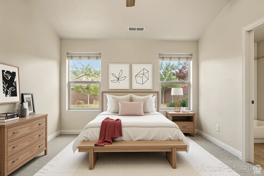 Bedroom with multiple windows, light colored carpet, baseboards, and ceiling fan