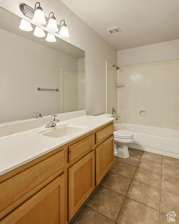 Full bathroom with vanity, toilet, tile patterned floors, and shower / tub combination