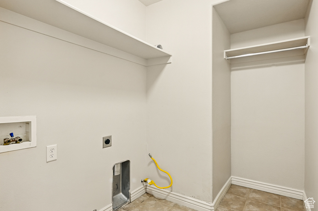 Laundry area with washer hookup, baseboards, electric dryer hookup, and light tile patterned flooring