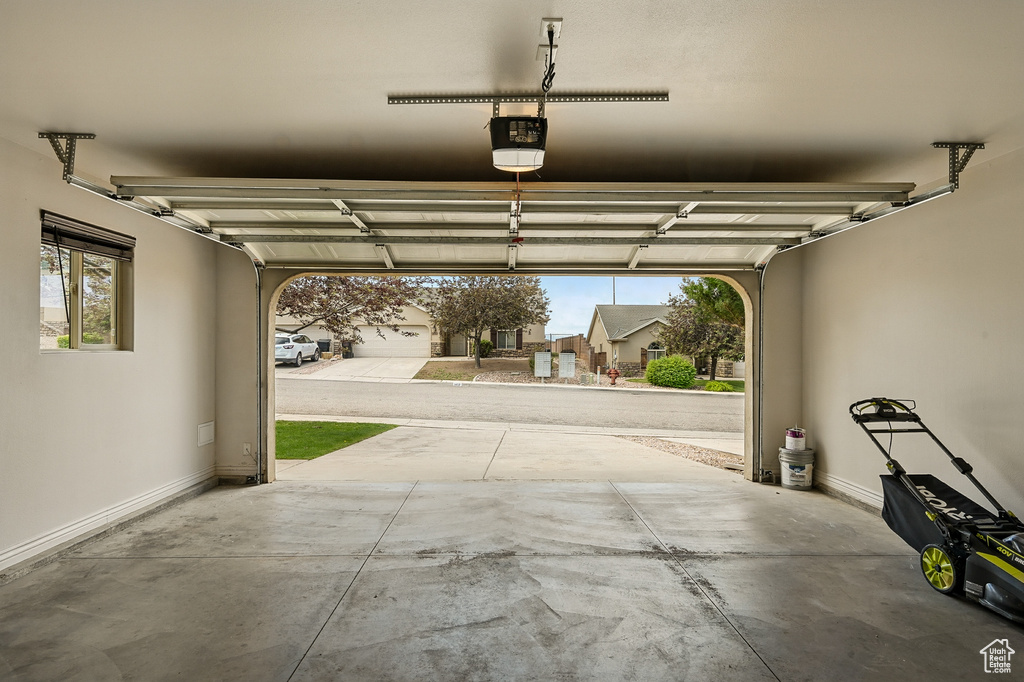 Garage featuring a garage door opener and baseboards
