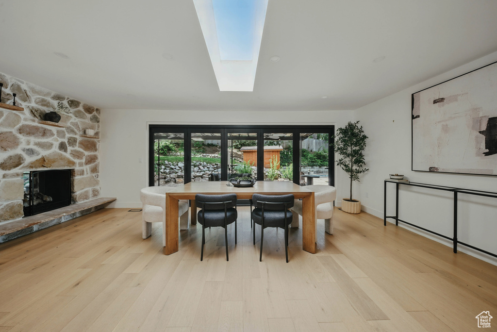Dining area with plenty of natural light, wood finished floors, and a fireplace