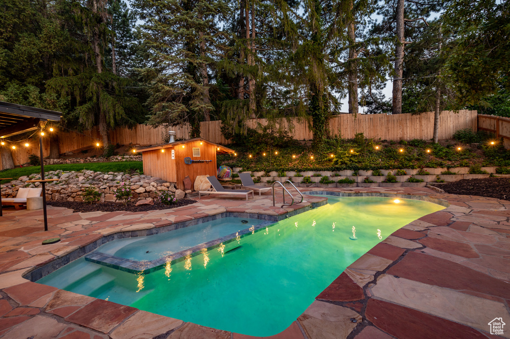View of pool with a patio area, a fenced backyard, and a pool with connected hot tub