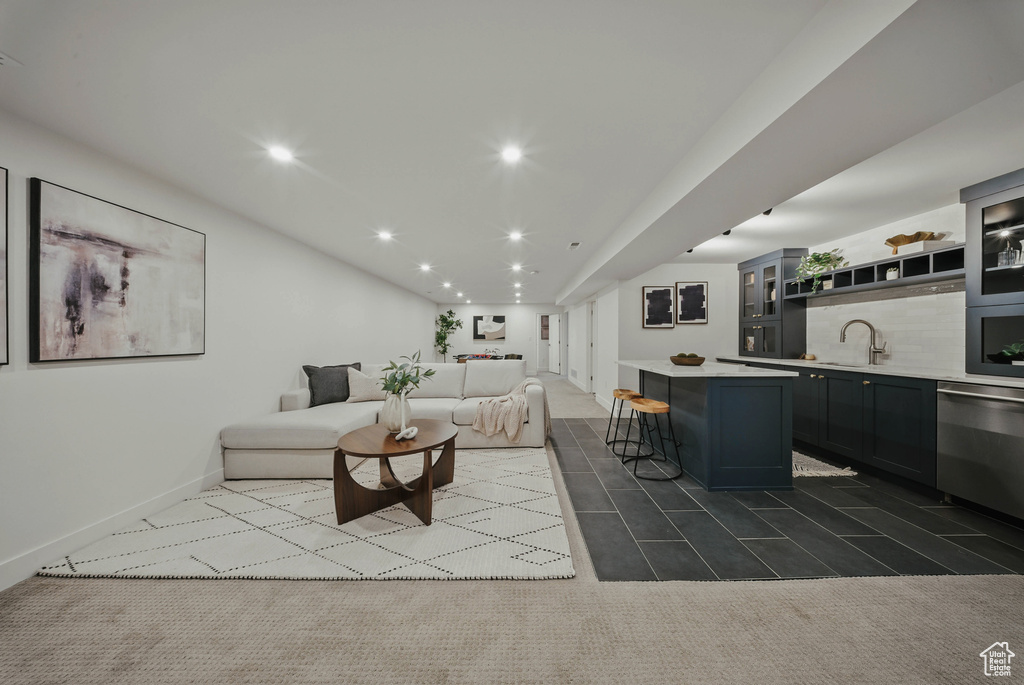 Living area with bar with sink, recessed lighting, baseboards, and dark tile patterned floors