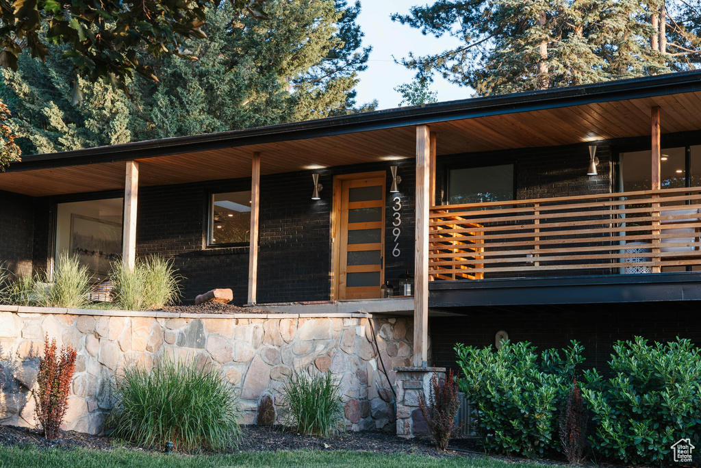View of front facade with stone siding and covered porch