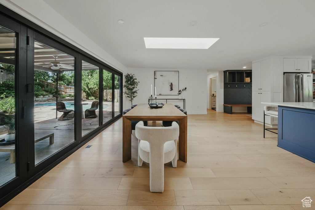 Recreation room with a skylight, light wood-type flooring, and recessed lighting