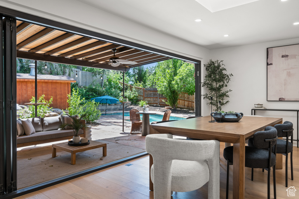 Dining space featuring hardwood / wood-style floors, recessed lighting, a ceiling fan, and a skylight
