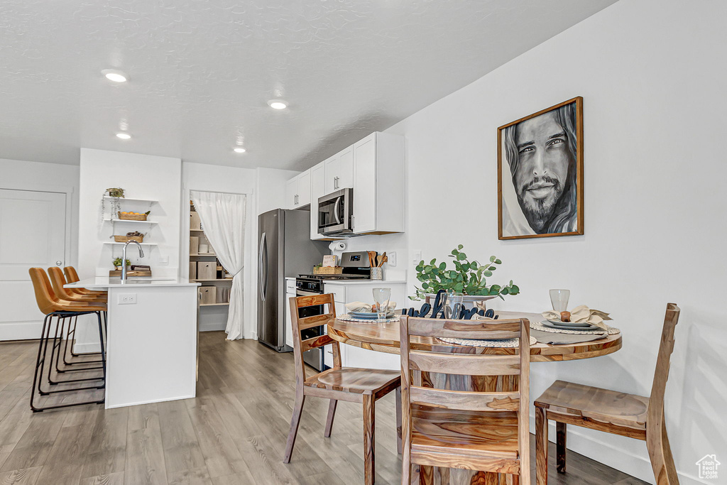 Dining area featuring light wood-type flooring and recessed lighting