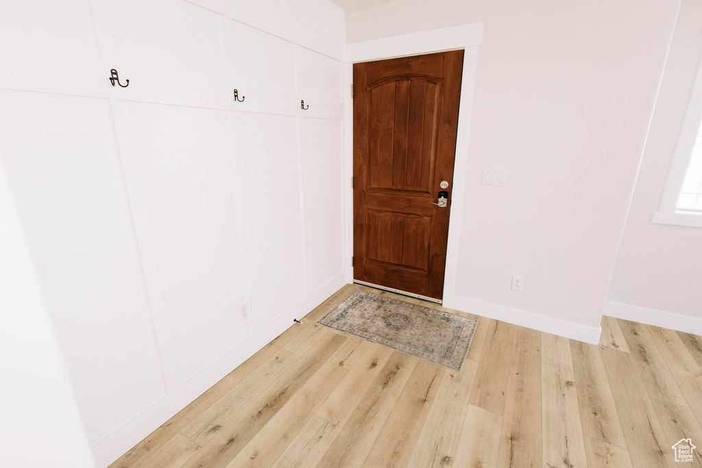 Foyer with light wood-type flooring and baseboards