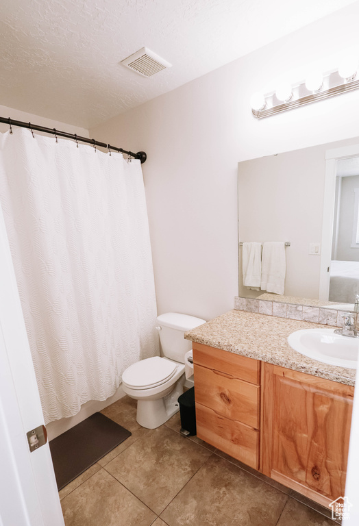 Full bath with vanity, tile patterned flooring, toilet, a shower with curtain, and a textured ceiling