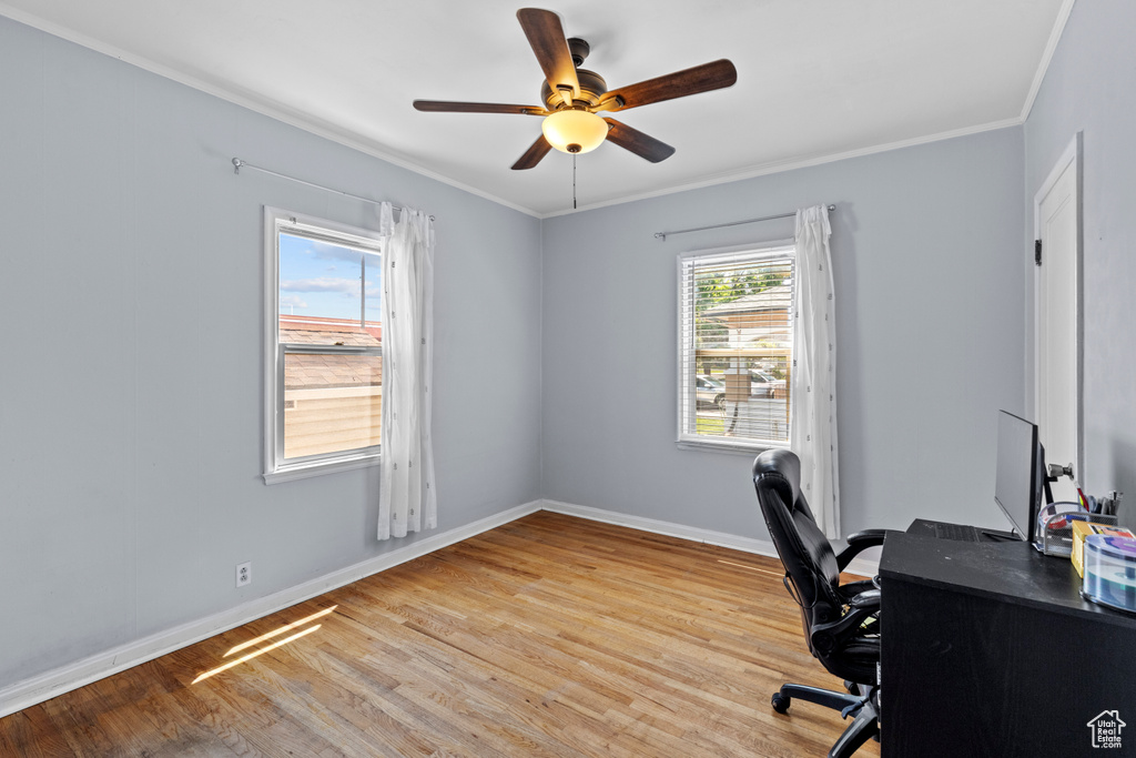 Office area featuring ornamental molding, wood finished floors, baseboards, and a ceiling fan