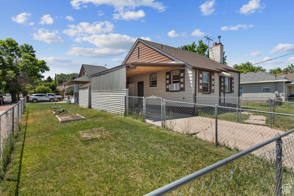 View of front of house featuring a carport, a chimney, cooling unit, and a shingled roof