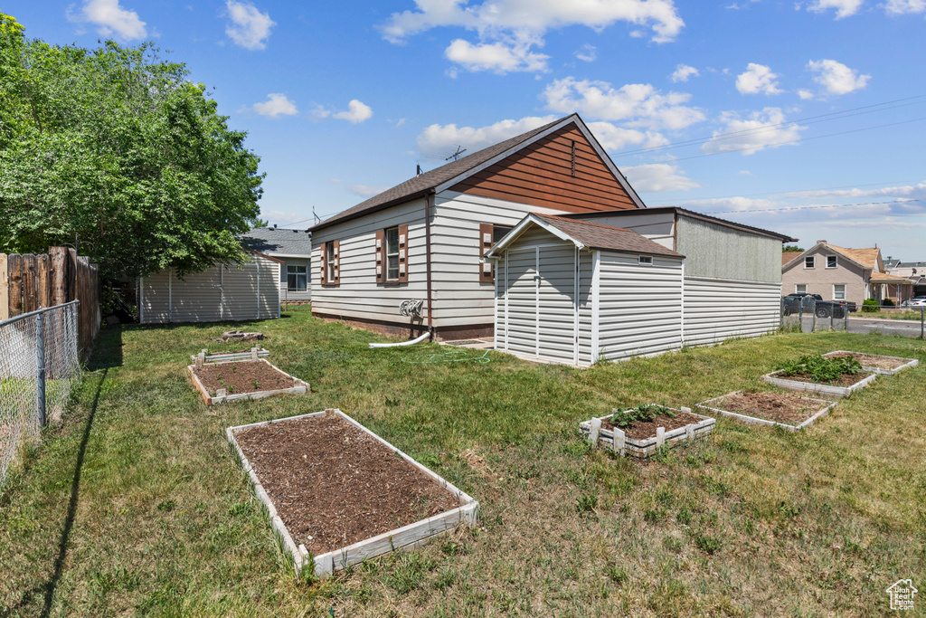 Rear view of house with a garden and roof with shingles