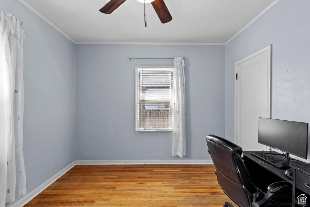 Office area featuring light wood-style flooring, ceiling fan, ornamental molding, and baseboards