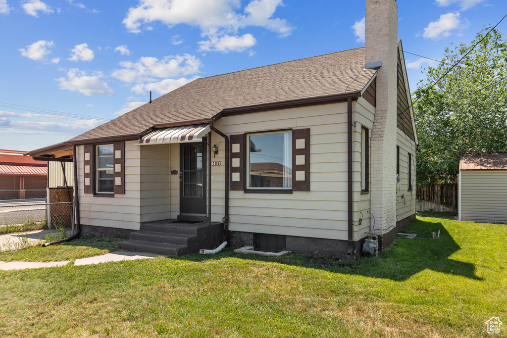 Bungalow featuring roof with shingles and a chimney