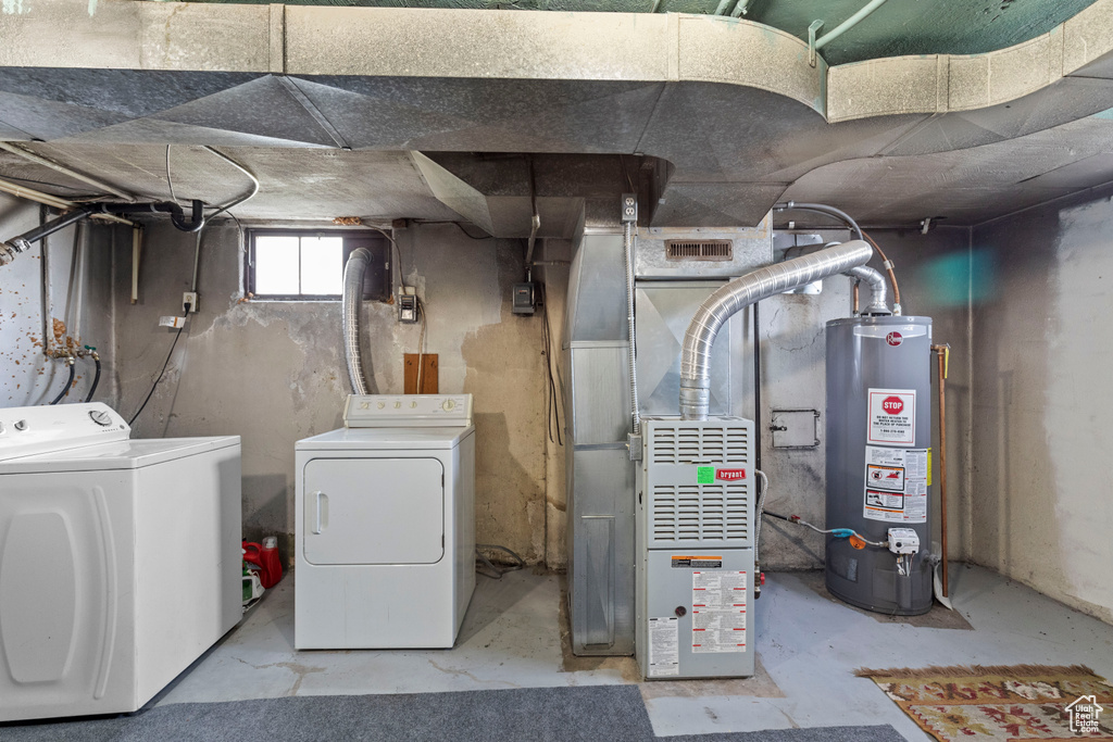 Below grade area with water heater, washer and clothes dryer, and heating unit