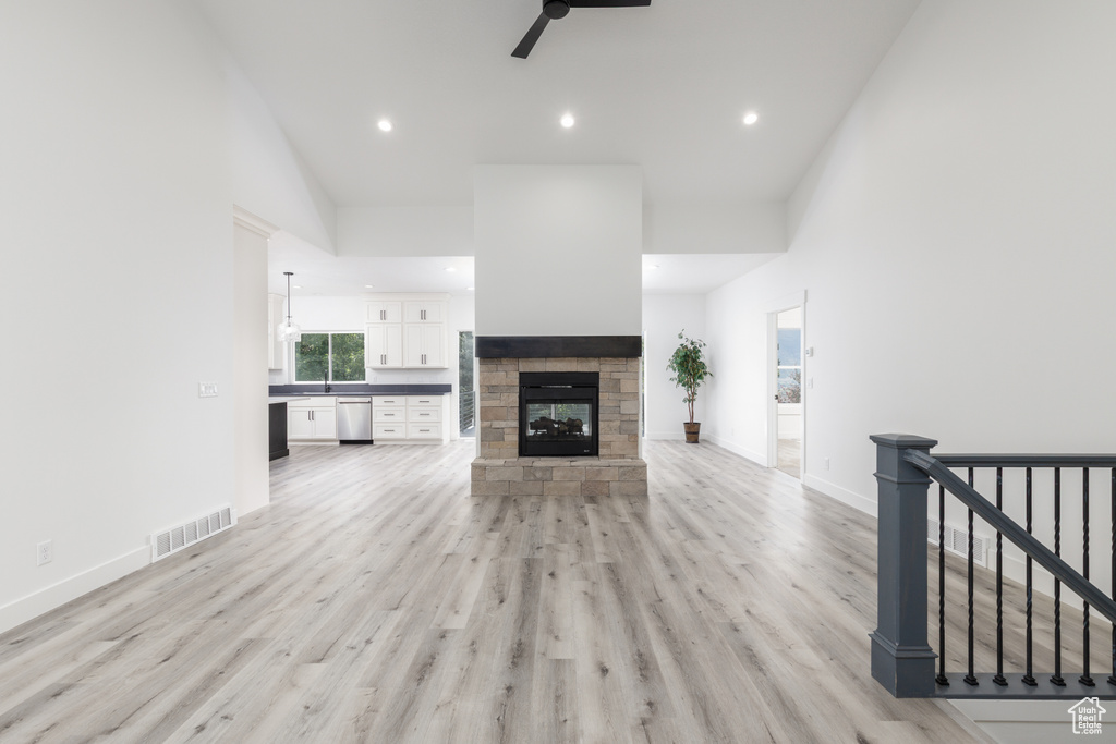 Unfurnished living room with ceiling fan, recessed lighting, light wood-style floors, a fireplace, and baseboards