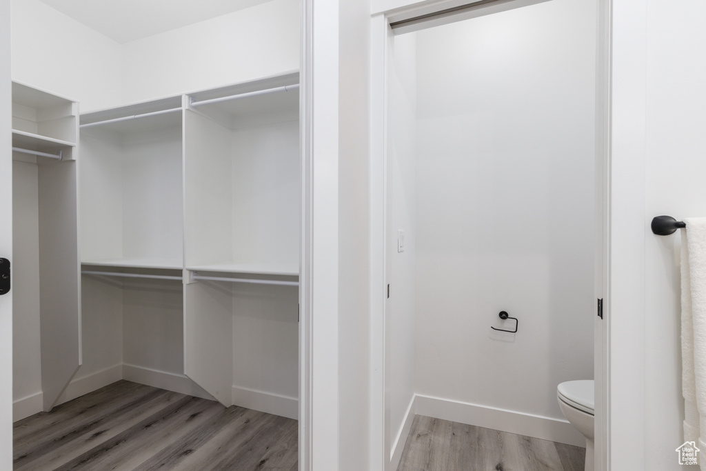 Walk in closet with light wood finished floors