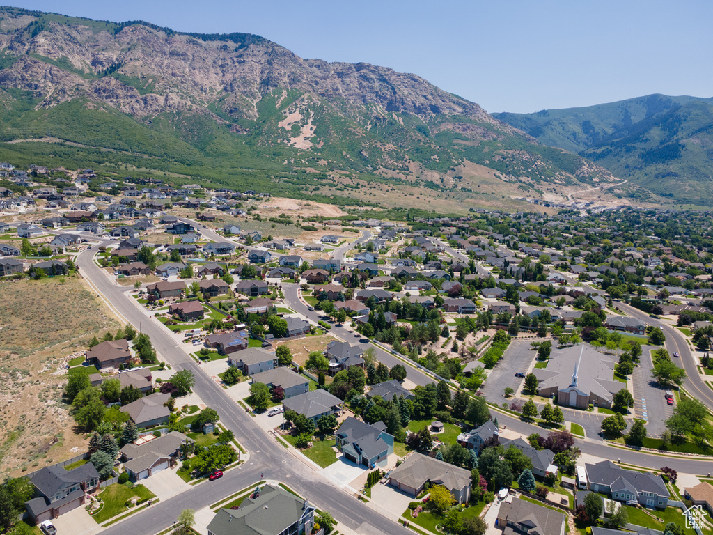 Aerial view of property and surrounding area with mountains and nearby suburban area