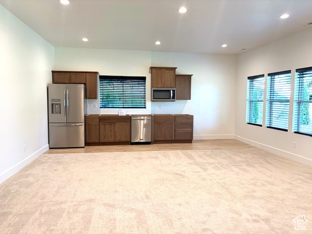 Kitchen featuring stainless steel appliances, recessed lighting, and light carpet