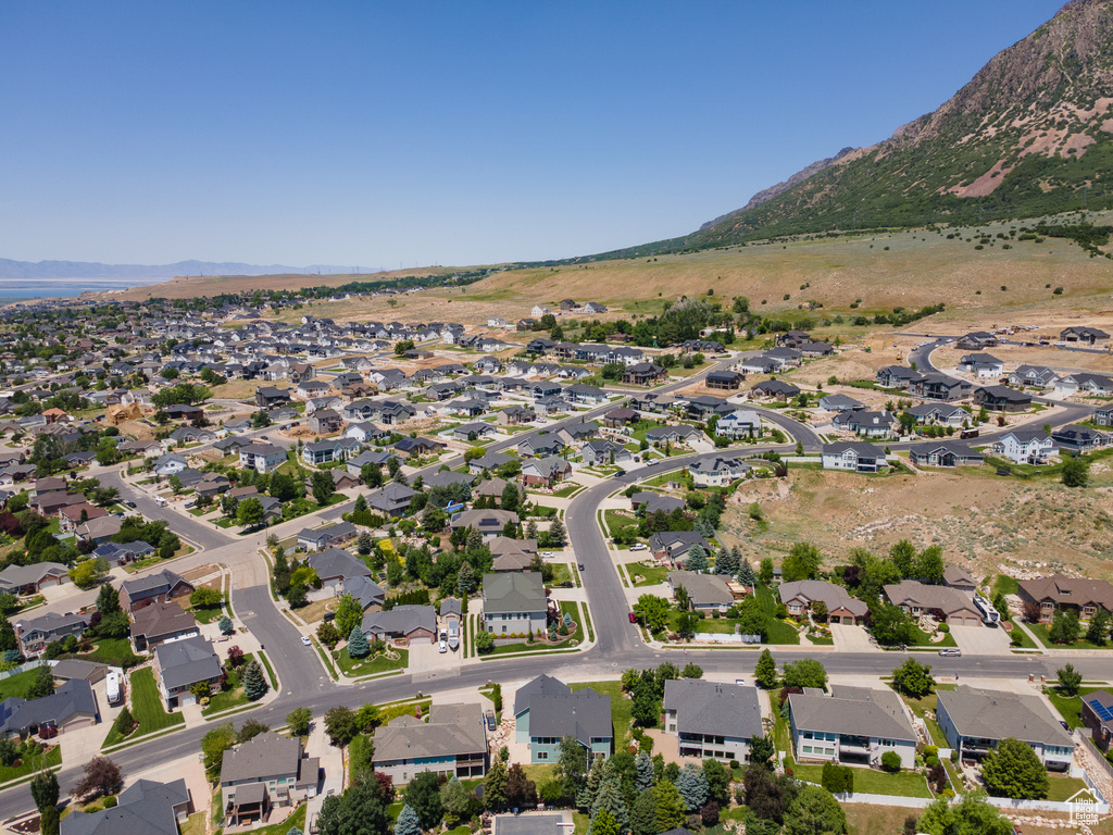 Aerial view of property and surrounding area featuring a mountain backdrop and nearby suburban area