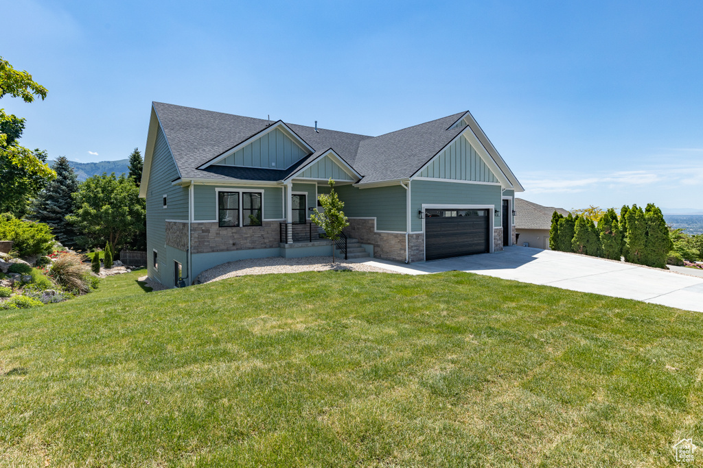 Craftsman-style house featuring board and batten siding, concrete driveway, and a front lawn
