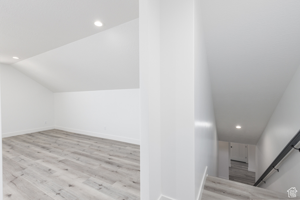 Staircase featuring wood finished floors, recessed lighting, vaulted ceiling, and baseboards