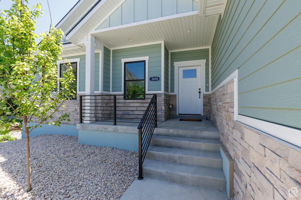 View of exterior entry featuring stone siding and board and batten siding