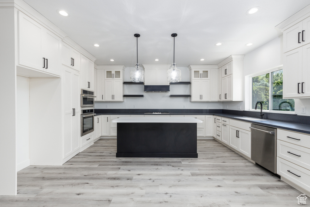Kitchen featuring stainless steel appliances, a sink, recessed lighting, white cabinetry, and dark countertops