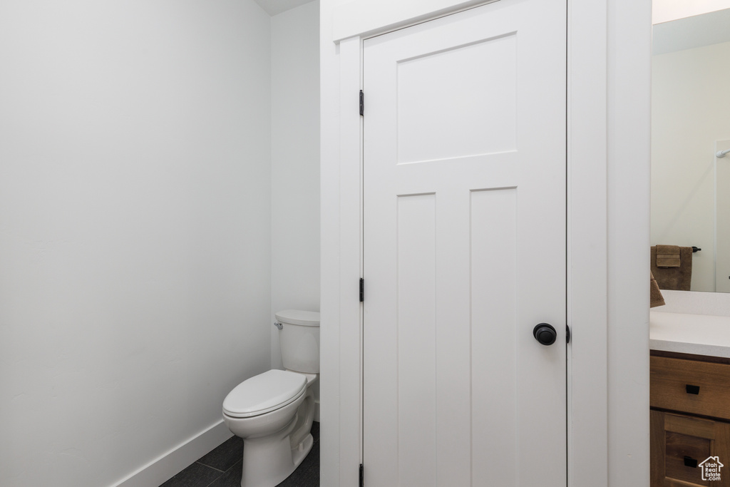 Bathroom with baseboards, vanity, and toilet