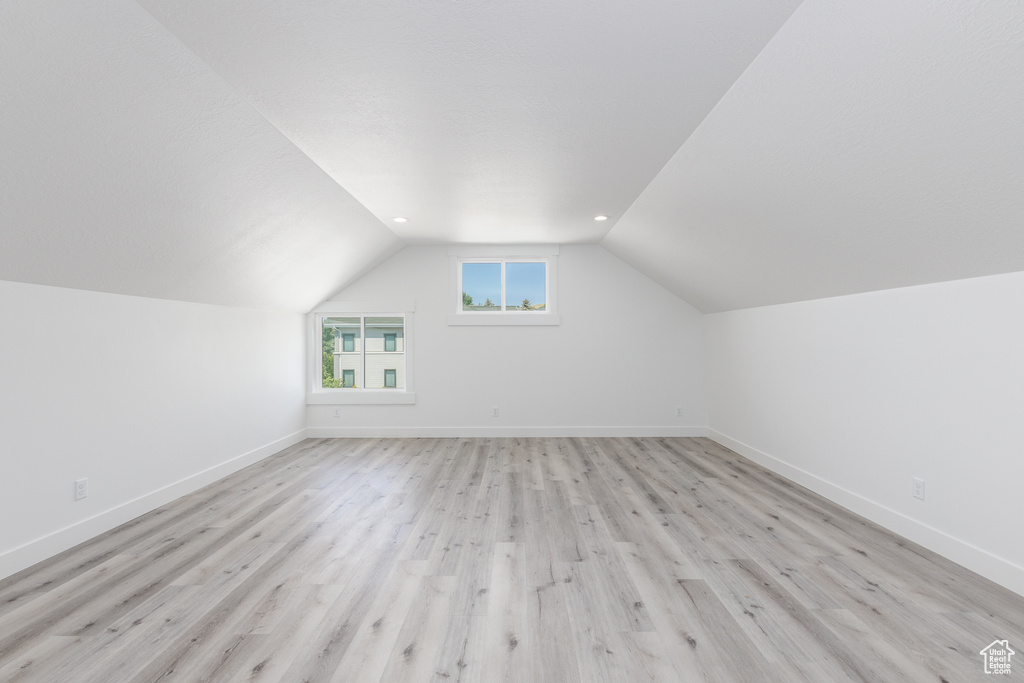 Bonus room featuring lofted ceiling, baseboards, and light wood finished floors