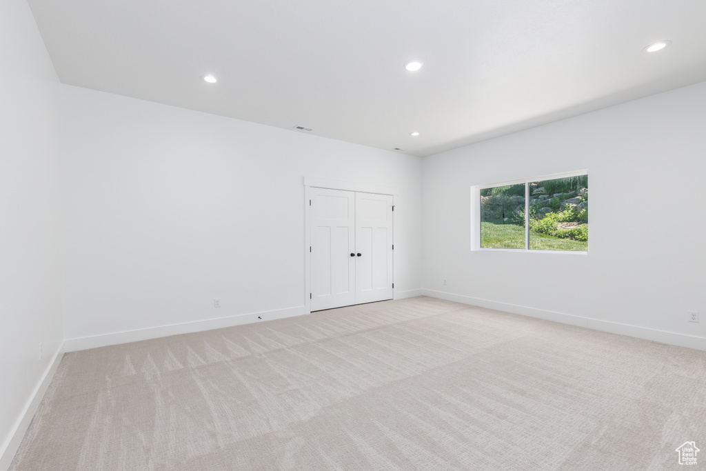 Unfurnished bedroom with light colored carpet, recessed lighting, baseboards, and a closet