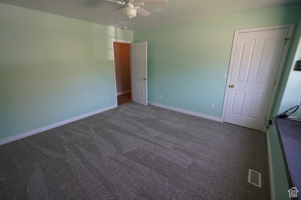 Unfurnished bedroom with carpet, baseboards, and ceiling fan