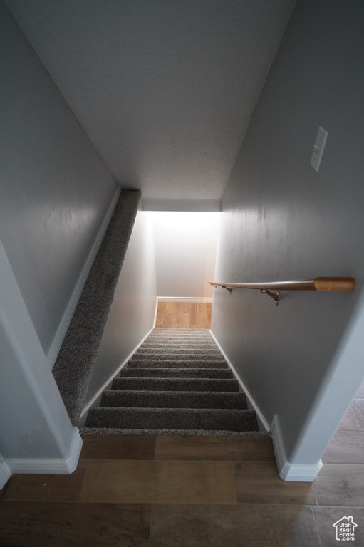 Staircase with baseboards and wood finished floors
