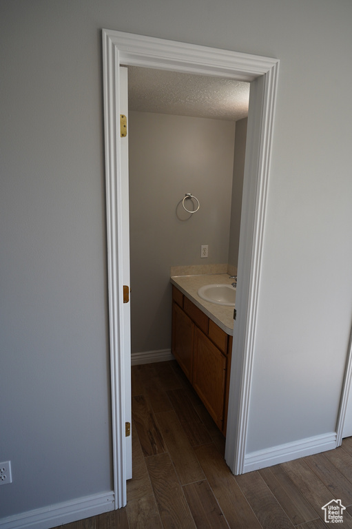 Bathroom featuring wood finished floors, vanity, and baseboards