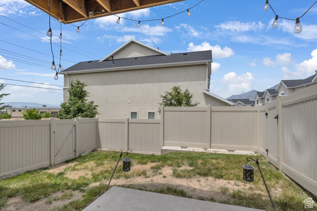 Fenced backyard featuring a gate and a patio area