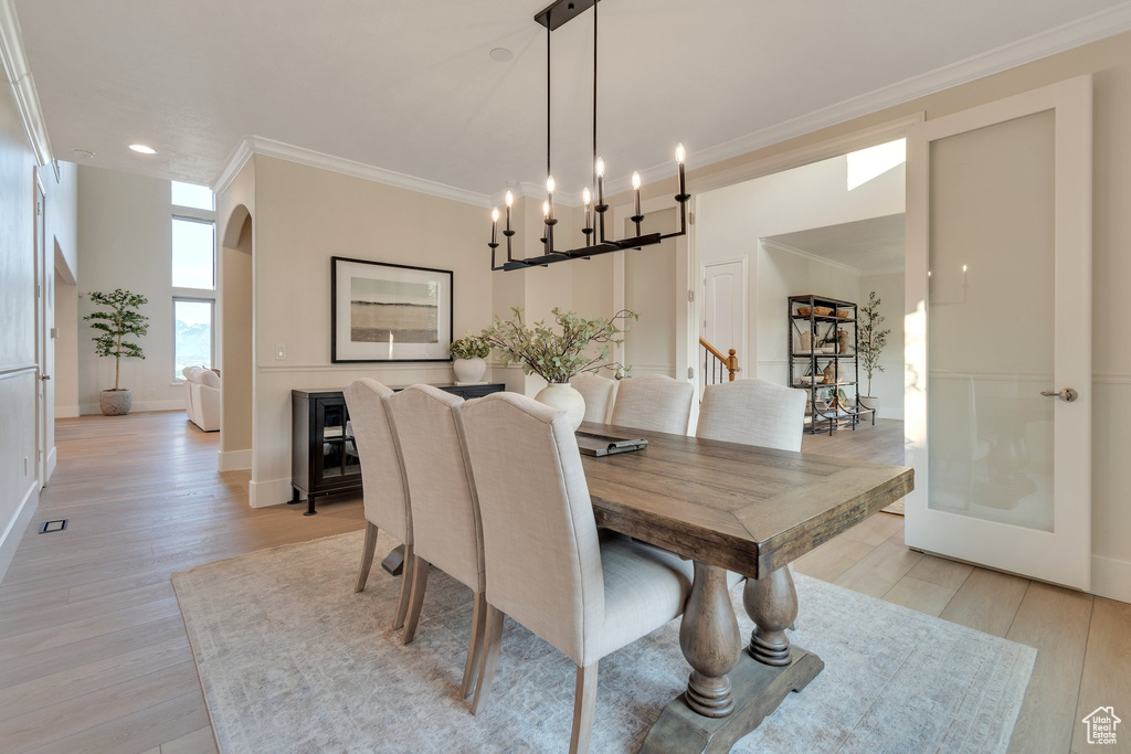 Dining area with crown molding, light wood-type flooring, recessed lighting, and baseboards