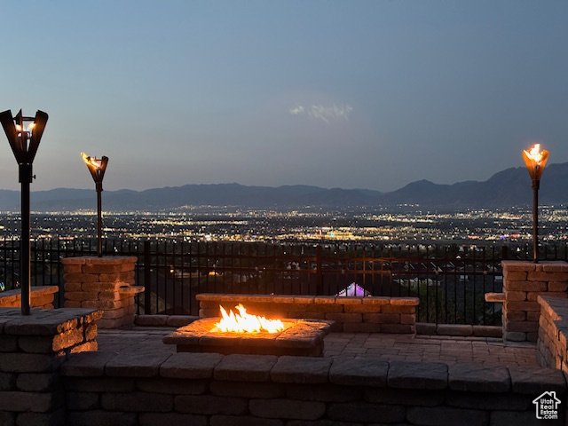 View of patio / terrace with an outdoor fire pit and a mountain view