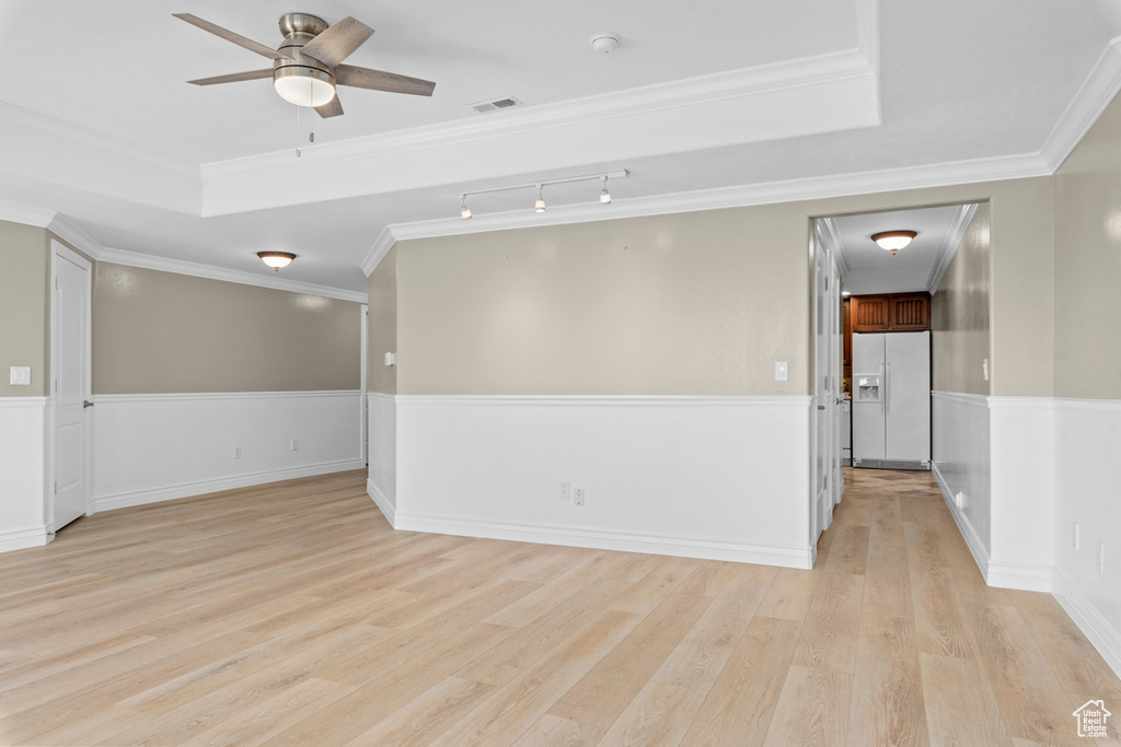 Unfurnished room with light wood finished floors, ceiling fan, a smoke detector, crown molding, and track lighting