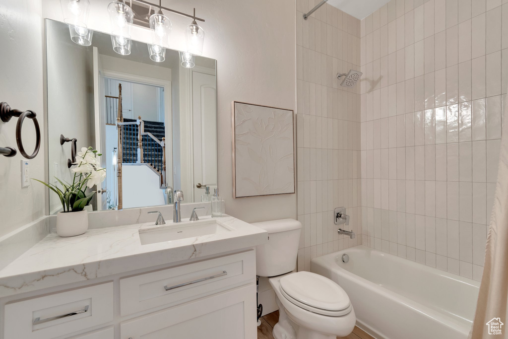 Full bathroom featuring tub / shower combination, vanity, and toilet