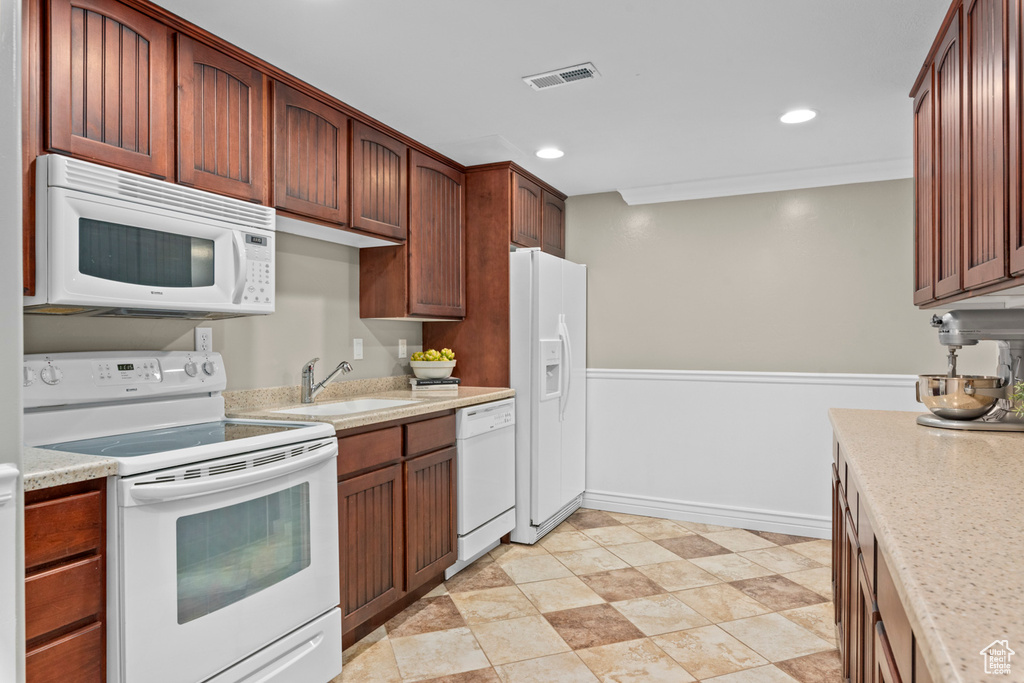 Kitchen featuring white appliances, a sink, recessed lighting, and baseboards