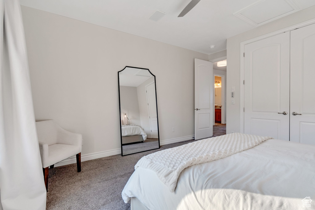 Carpeted bedroom with a closet, baseboards, ceiling fan, and attic access