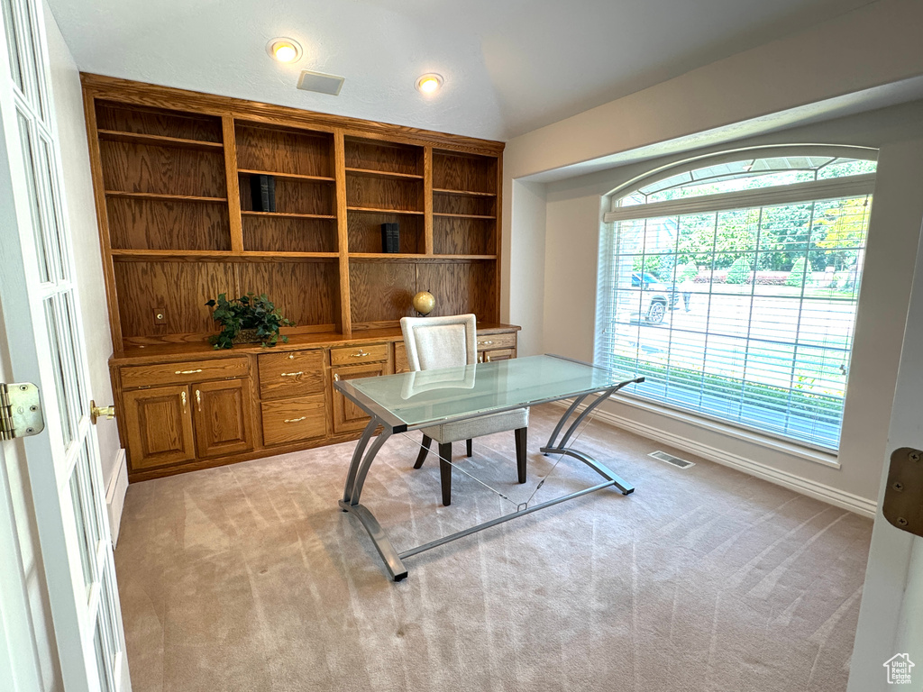 Office with light colored carpet and baseboards