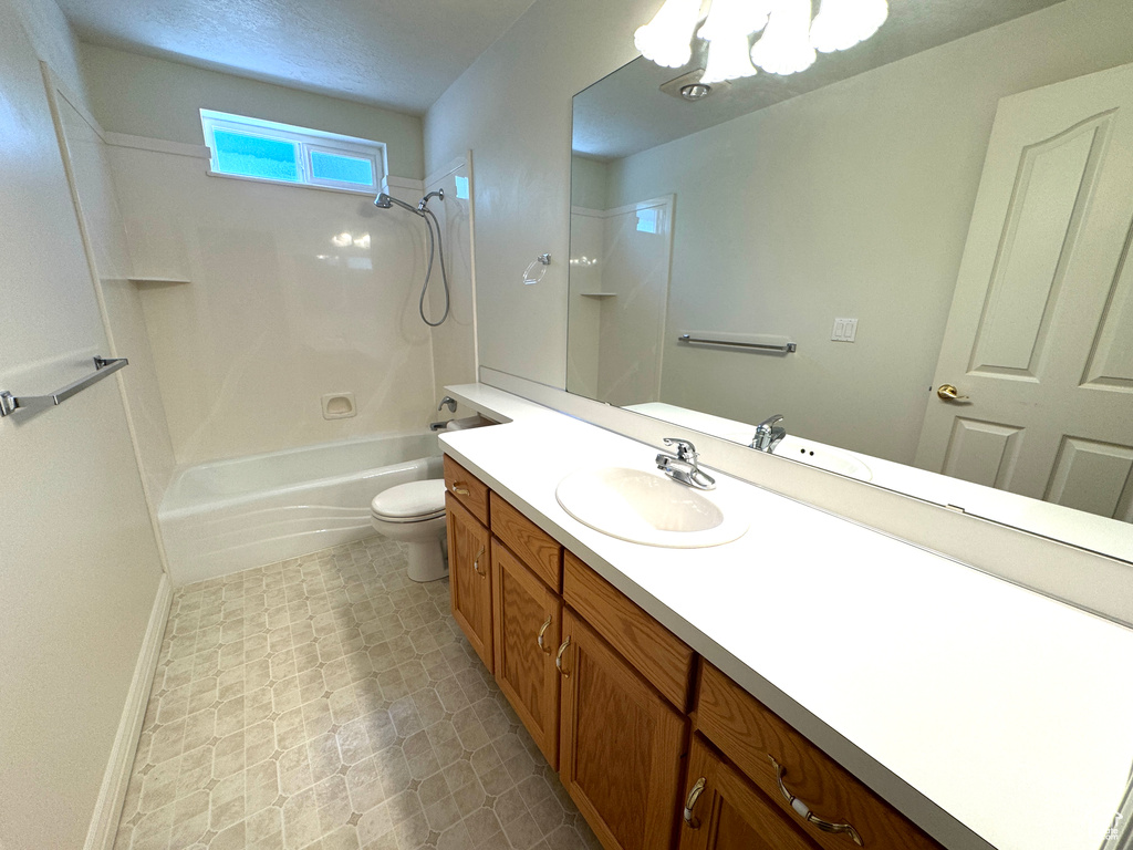 Bathroom with vanity, shower / bathtub combination, toilet, baseboards, and tile patterned floors