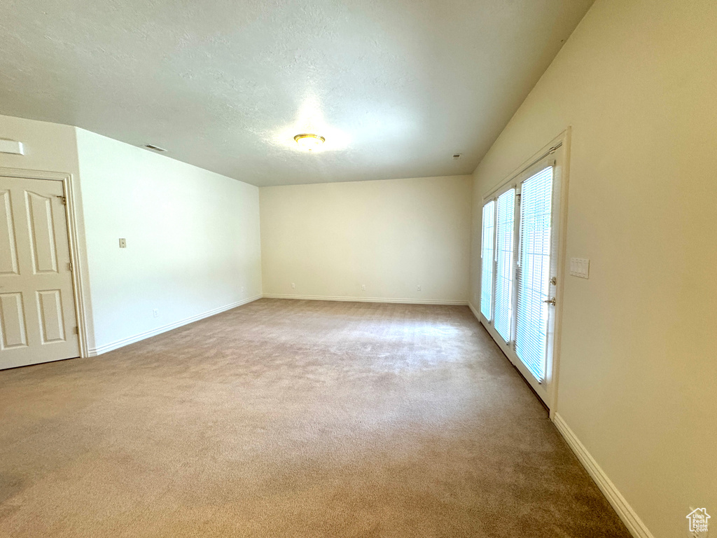Unfurnished room featuring carpet floors, a textured ceiling, and baseboards