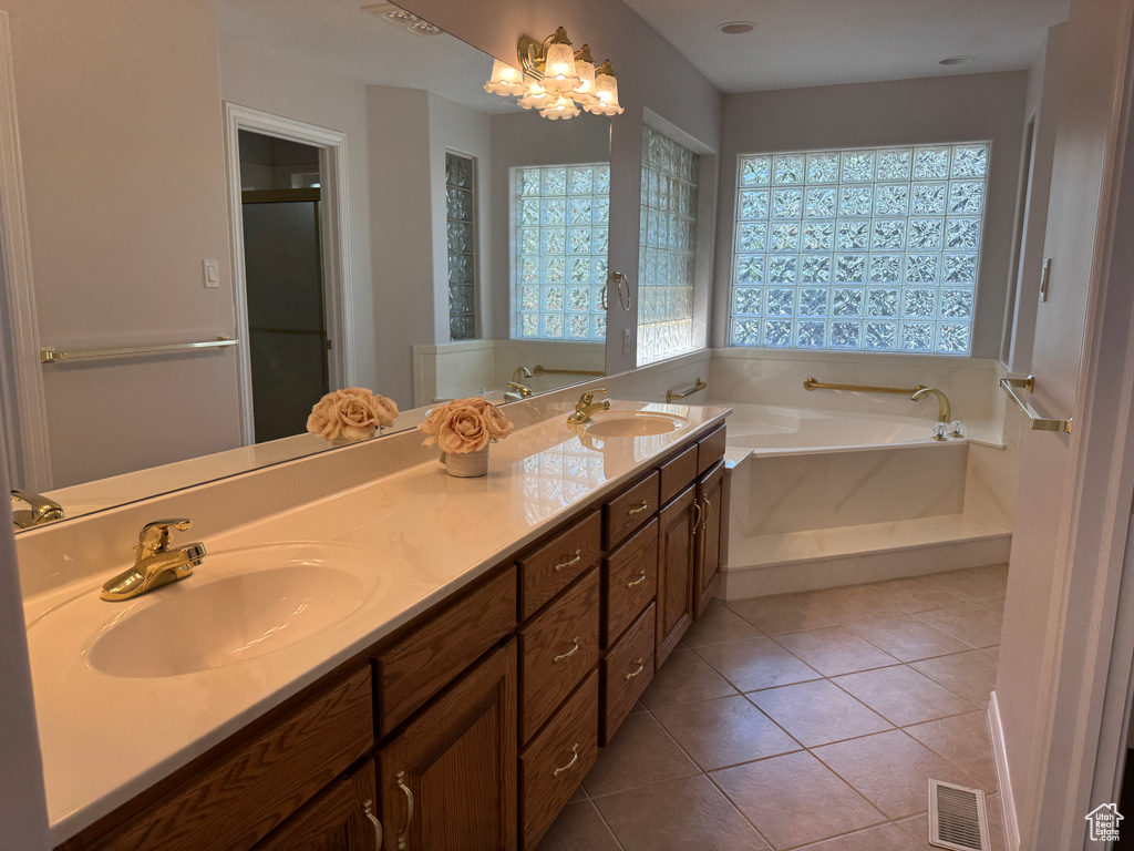 Bathroom featuring a bath, double vanity, tile patterned flooring, and a stall shower