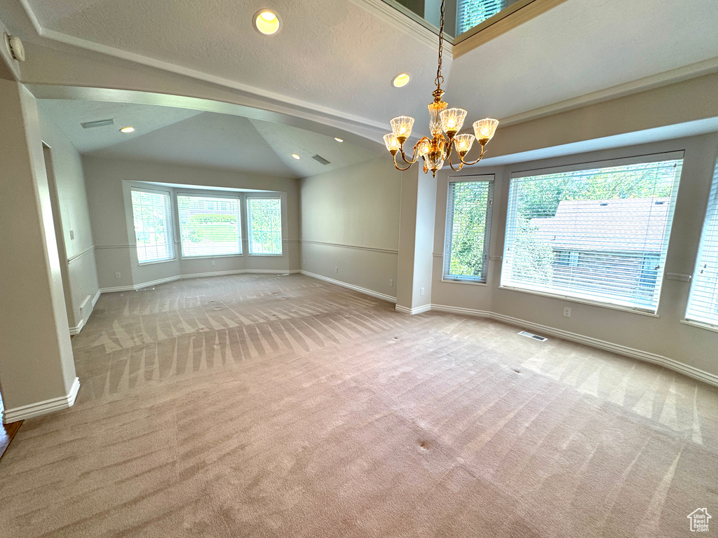 Unfurnished room featuring vaulted ceiling, carpet floors, a chandelier, baseboards, and recessed lighting
