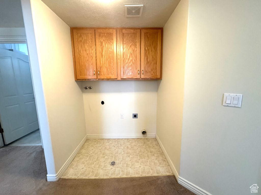 Washroom featuring electric dryer hookup, cabinet space, baseboards, and carpet