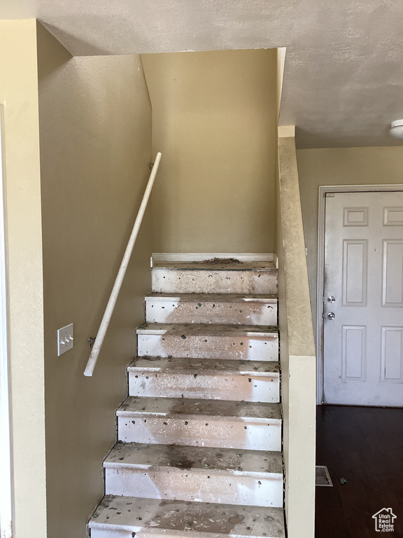 Stairs featuring wood finished floors